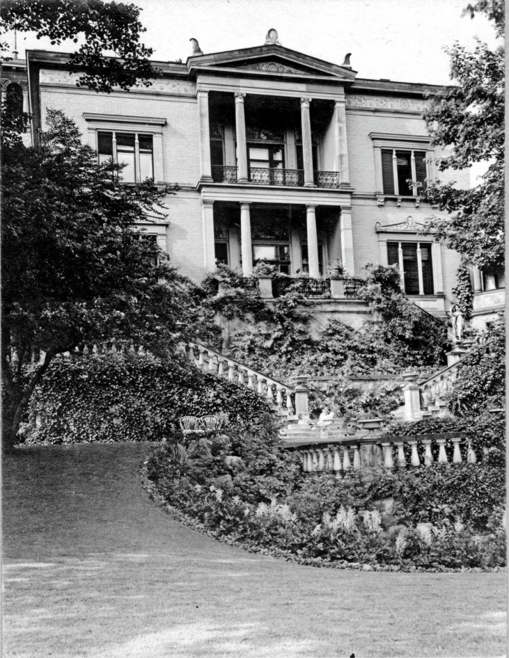 Henschel Villa: Im Vordergrund der mit Balustraden umgebene und mit Stauden und Kletterpflanzen bewachsene Brunnen. © Stadt Kassel